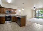 Thumbnail 6 of 17 - A kitchen with brown cabinets and a black refrigerator.