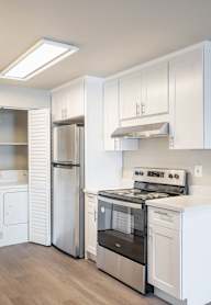 A kitchen with white cabinets and stainless steel appliances.