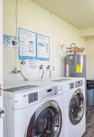 A laundry room with washers and dryers and a sign on the wall.