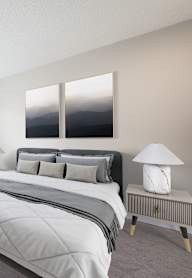 A bedroom with a large bed and a window overlooking a body of water.