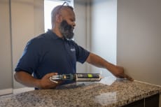 a man drilling into a counter top with a drill
