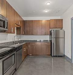 A kitchen with brown cabinets and stainless steel appliances.