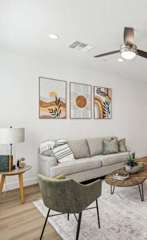 A living room with a couch, chairs, and a rug.