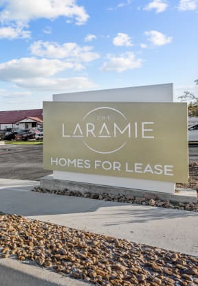 the laramie homes for lease sign in front of the building