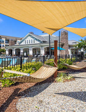 A yellow canopy over a gravel area with a hammock.