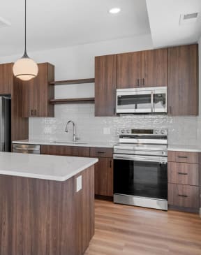 a kitchen with wooden cabinets and a white counter top at The Mera, St Louis Park, MN 55426