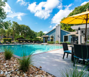 our apartments have a large swimming pool with chairs and umbrellas