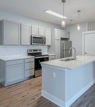 an open kitchen with a large island and white cabinets