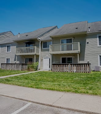 an apartment building with a sidewalk in front of it