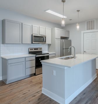 an open kitchen with a large island and white cabinets