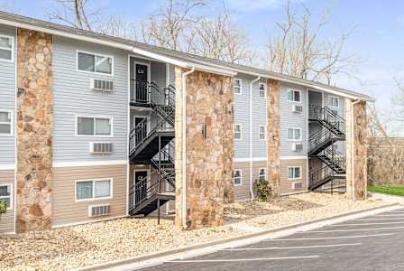 Apartment building with stone pillars and staircases.