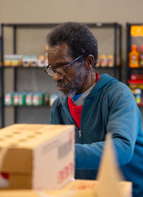 a man working in a warehouse with a box