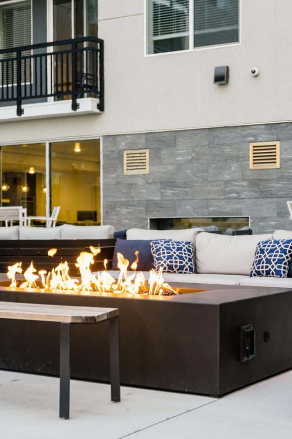 the outdoor patio of a building with a fire pit