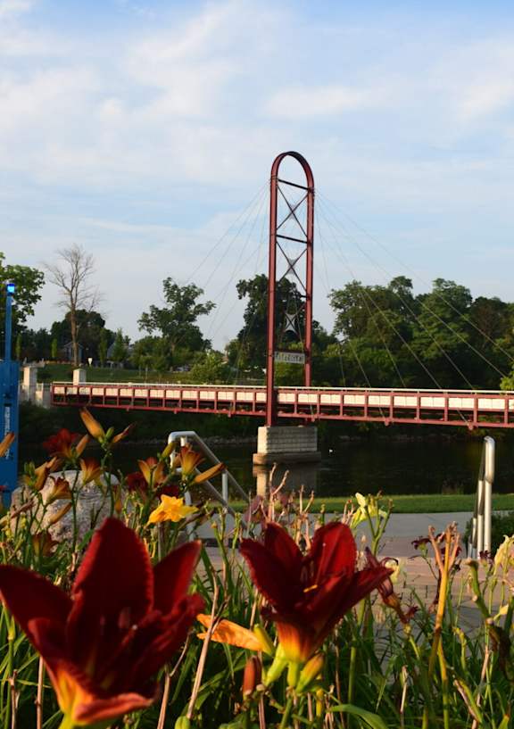 A bridge over a river with a red arch in the middle.