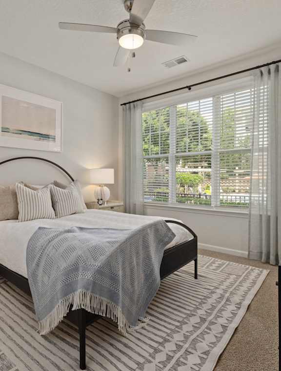 a bedroom with a bed and a ceiling fan