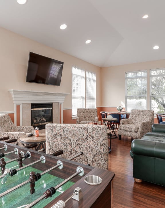 a living room with a foosball table and a green couch