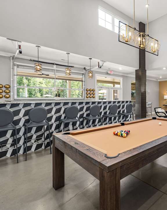 a game room with a pool table and a bar