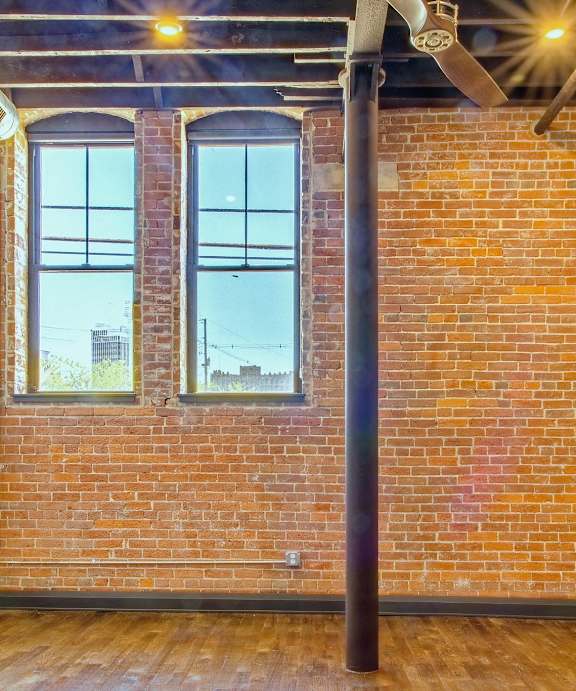 A room with a brick wall and a window.