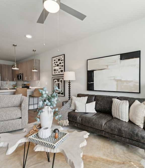 A modern living room with a wooden cabinet and a grey sofa at The Hendry Apartments, Fort Myers, FL, 33905