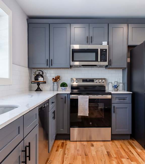A kitchen with a stainless steel refrigerator and a white countertop.
