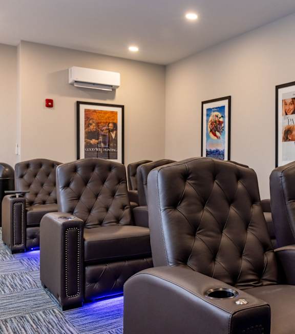 A row of black leather recliner chairs are lined up in a row.