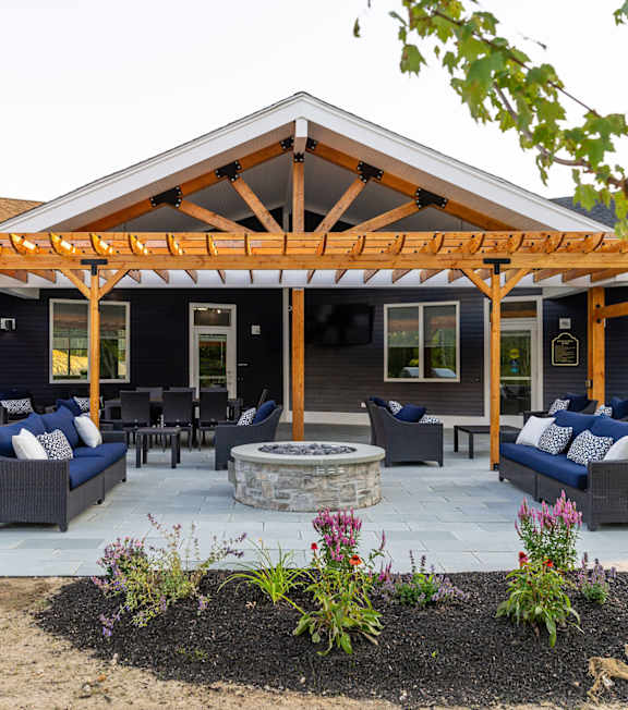 A covered patio with a fireplace and seating area.