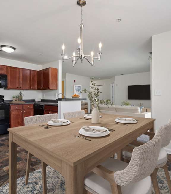 A dining room with a wooden table set for two.