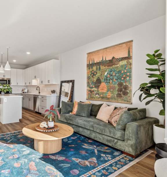 a living room with a white couch and a table with a vase of flowers