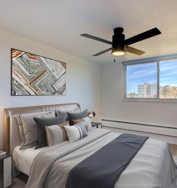 A bedroom with a large bed and a ceiling fan.
