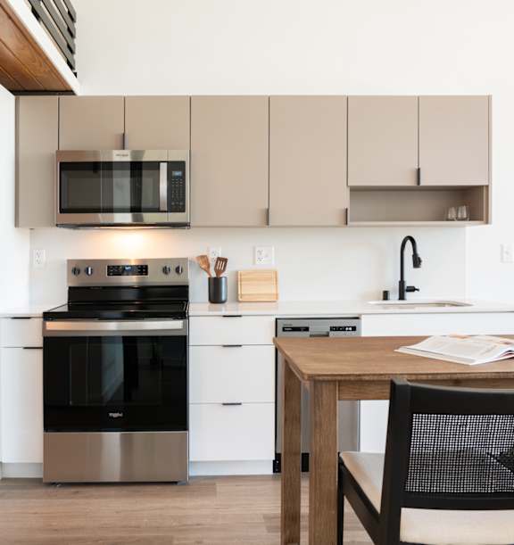 A modern kitchen with a black oven and white cabinets.