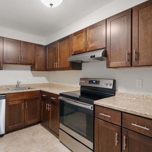 A kitchen with wooden cabinets and stainless steel appliances.