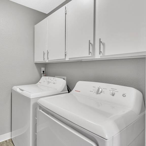 A white washing machine and dryer in a laundry room.