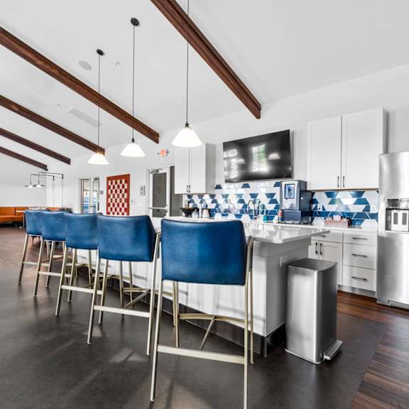 A kitchen with blue chairs and a white counter.