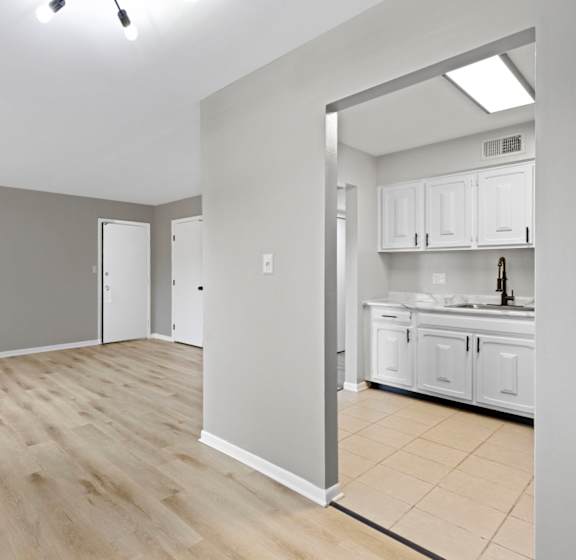A room with wooden flooring and white walls.