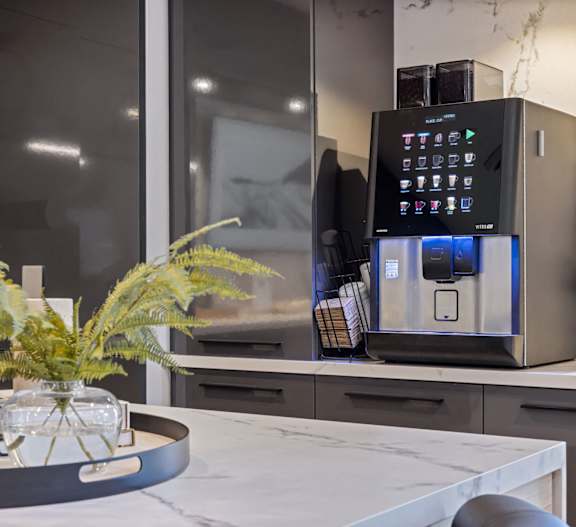 a kitchen counter with a coffee machine and a vase on it
