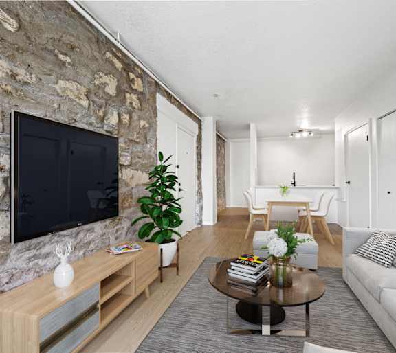 A living room with a couch, a coffee table, and a person in the kitchen.