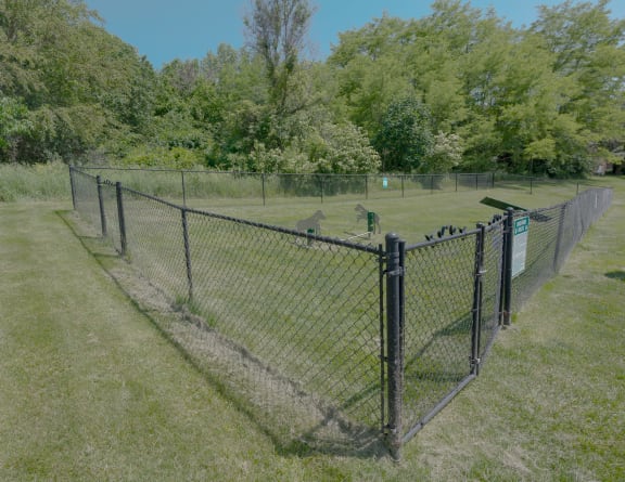 a chain link fence with a fence post and a wire fence in a field