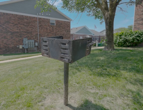 a mailbox in the grass in front of a brick house