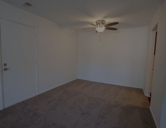 an empty room with a ceiling fan and a door