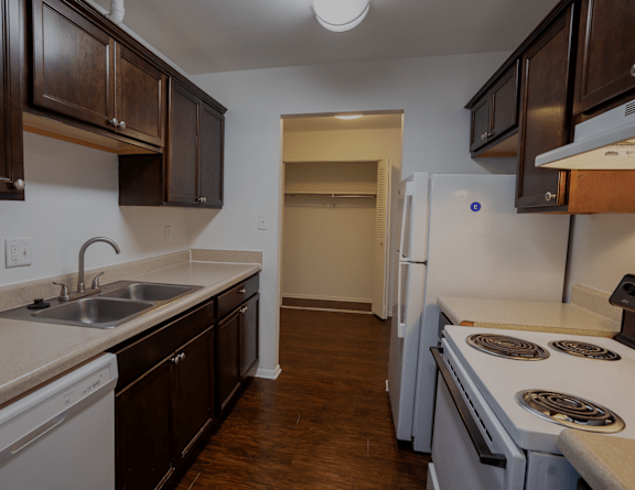 a kitchen with white appliances and dark wood cabinets