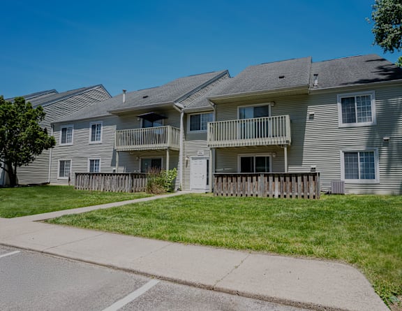an apartment building with a sidewalk in front of it