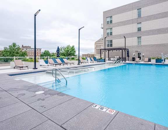 our resort style swimming pool is next to our building with lounge chairs