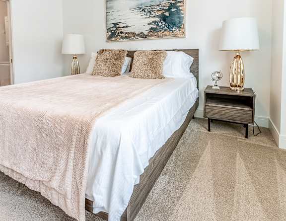 a bedroom with a large bed and two lamps