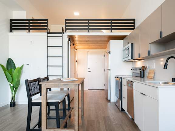 A modern kitchen with a dining table and chairs.