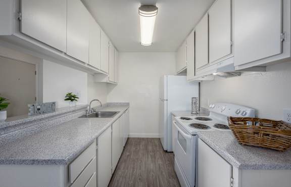 A kitchen with white appliances and cabinets.