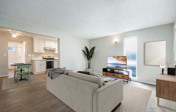 A living room with a couch, a table, and a plant.