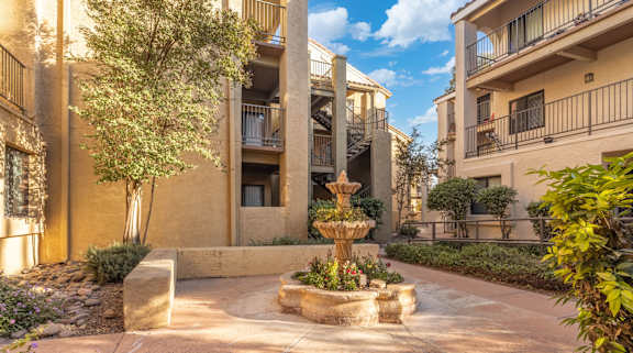 A courtyard with a fountain and plants.