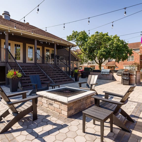 a patio with tables and chairs and a fire pit