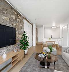 A living room with a stone wall and a flat screen TV at Tallmadge Lofts in Denver, CO 80211