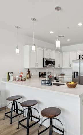 A kitchen with white cabinets and a white island with a counter top.